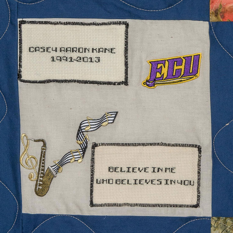 Quilt square for Casey Kane with saxophone, ECU logo, and text reading believe in me who believes in you.