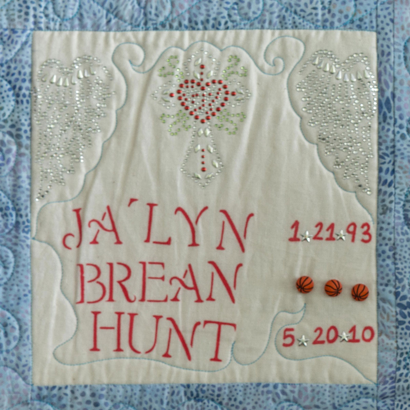 Quilt square for Jalyn Hunt with heart and cross, and three basketballs.