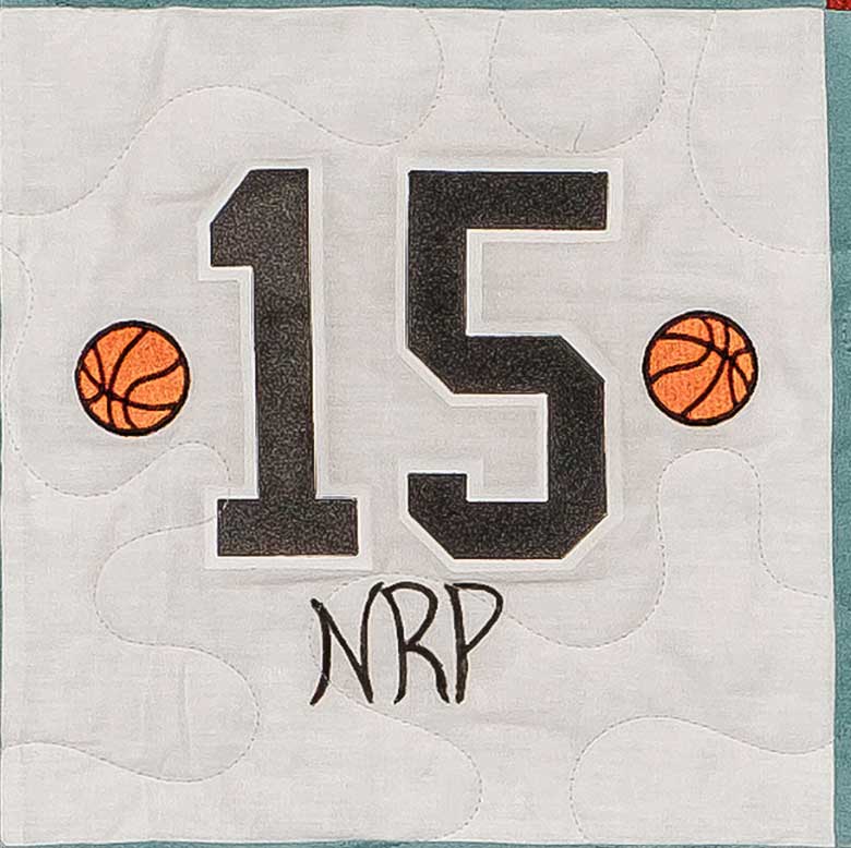 Quilt square for Nicolas Patrick with the number 15 in the center, basketballs on either side, and text reading NRP.