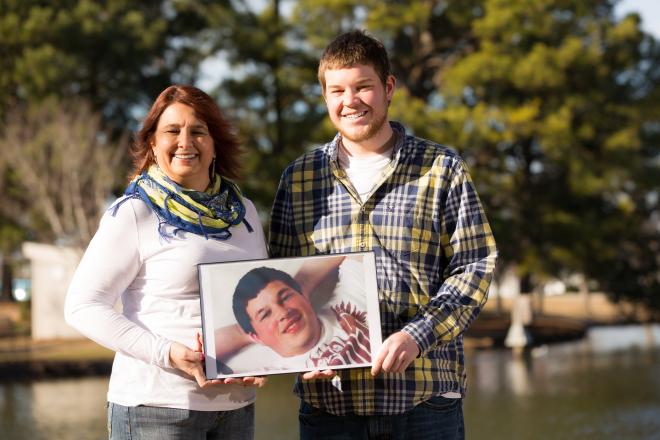 Organ donor mom, Angie, hold's photo of son by lake