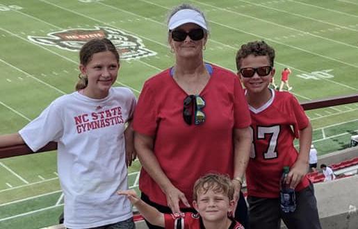 Organ Donor Debbie standing with kids at an NC State event