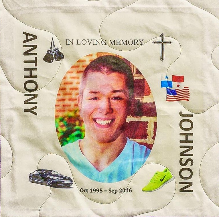 Quilt square for Anthony Johnson with a portrait of Anthony alongside patches of boxing gloves, a black sedan, Nike shoes, a cross, and flags.