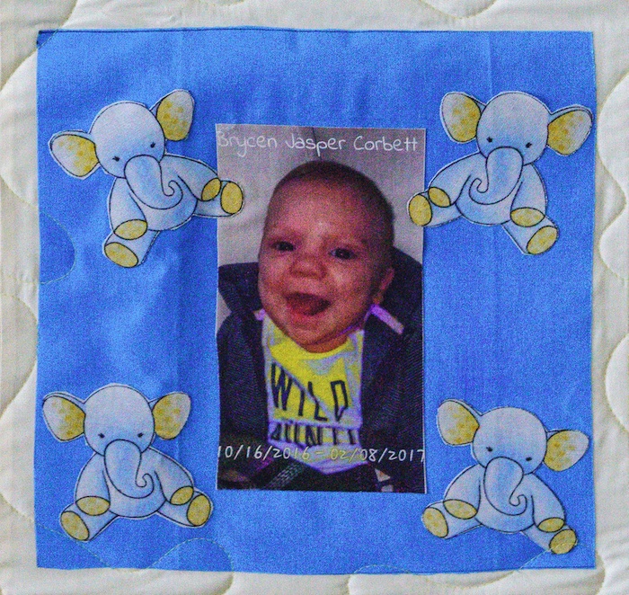 Quilt square for Brycen Corbett with a portrait of a baby Brycen and patches of elephants
