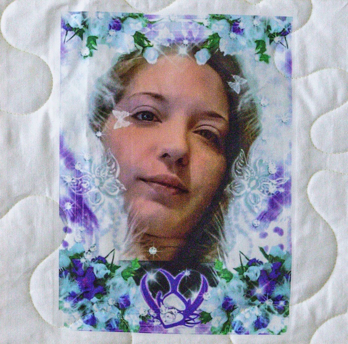 Quilt square for Christy Harris with portrait of Christy surrounded by flowers, butterflies, and sparkles.