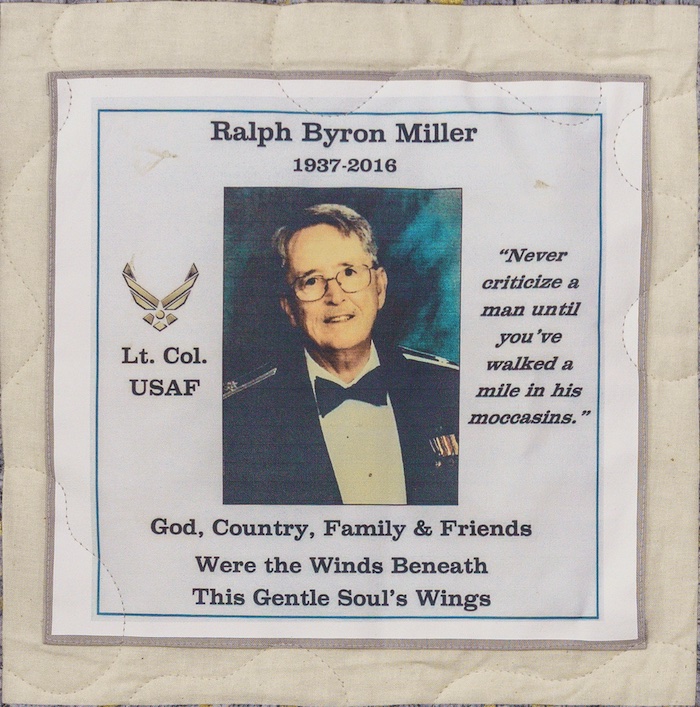 Quilt square for Ralph Miller with a photo of Ralph and text reading: Lt. Col. USAF, Never criticize a man until you’ve walked a mile in his moccasins. God, Country, Family & Friends Were the Winds Beneath this Gentle Soul’s Wings.