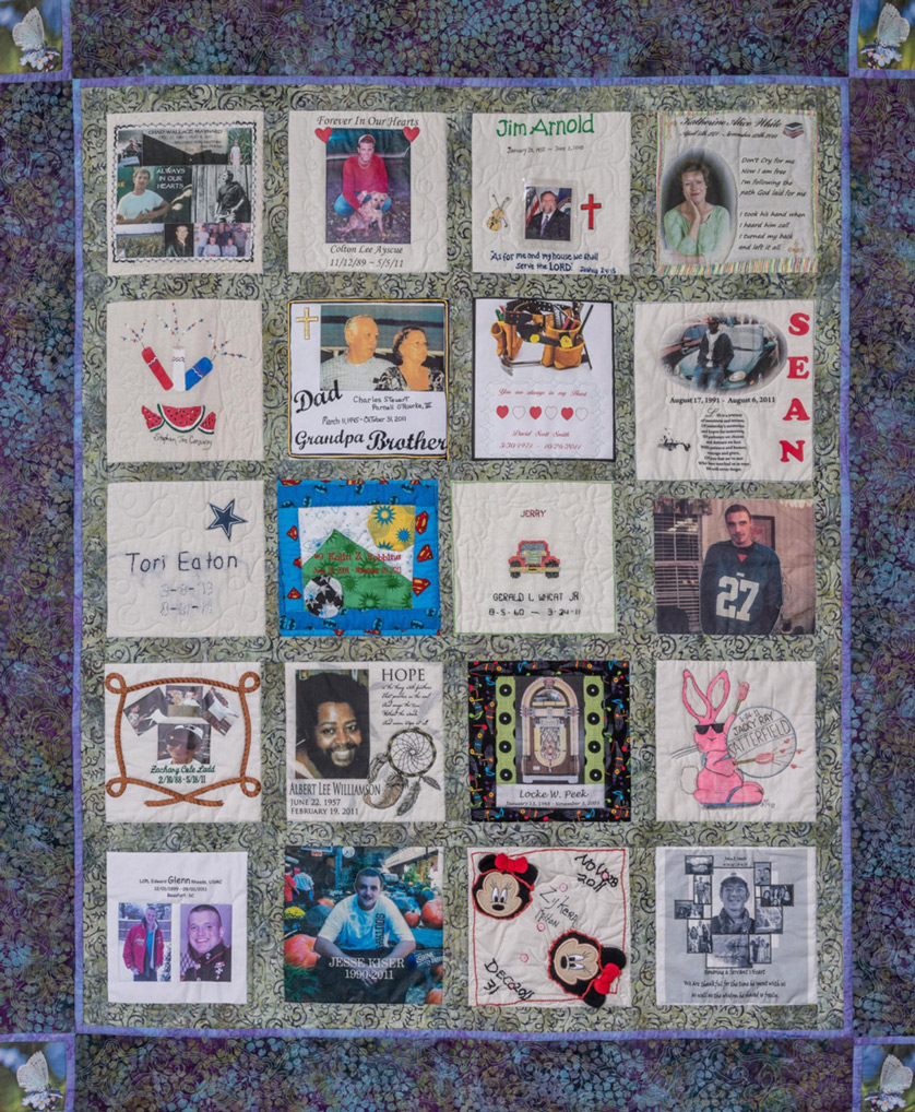Colorful quilt with purple and yellow patterns and butterfly pictures and 20 unique squares featuring donor names, photos, and memories