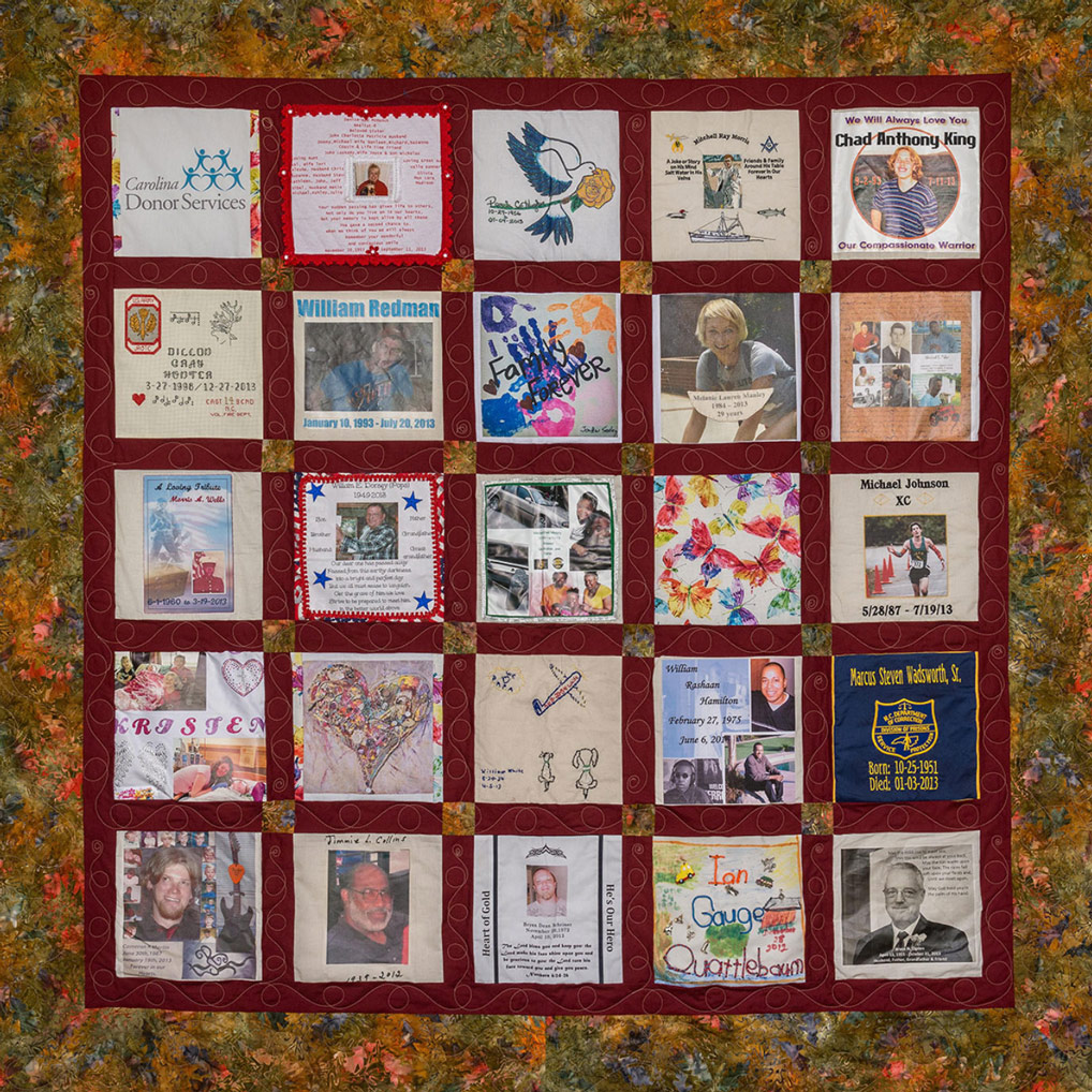 Colorful red quilt with leaf pattern and 25 unique squares featuring donor names, photos, and memories