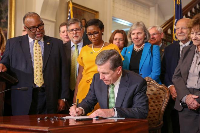 Governor Roy Cooper Signs a Document