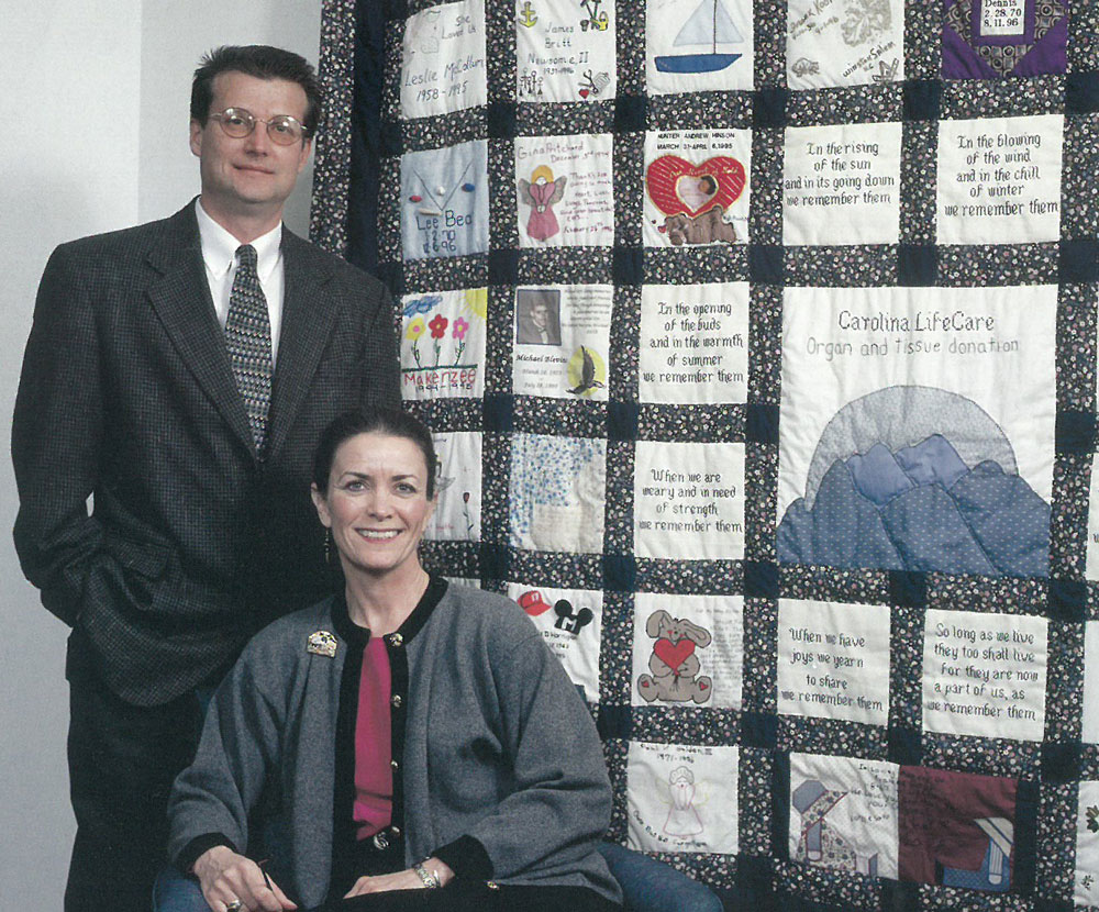 Photo from 1999 of staff in front of donor quilt