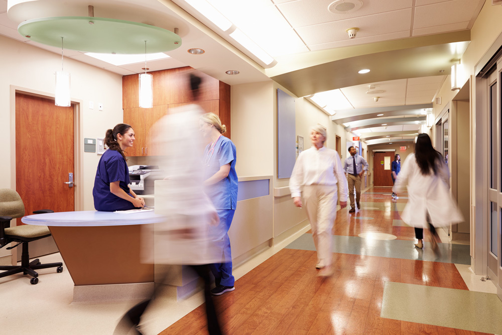 Multiple medical personnel moving through a busy hallway