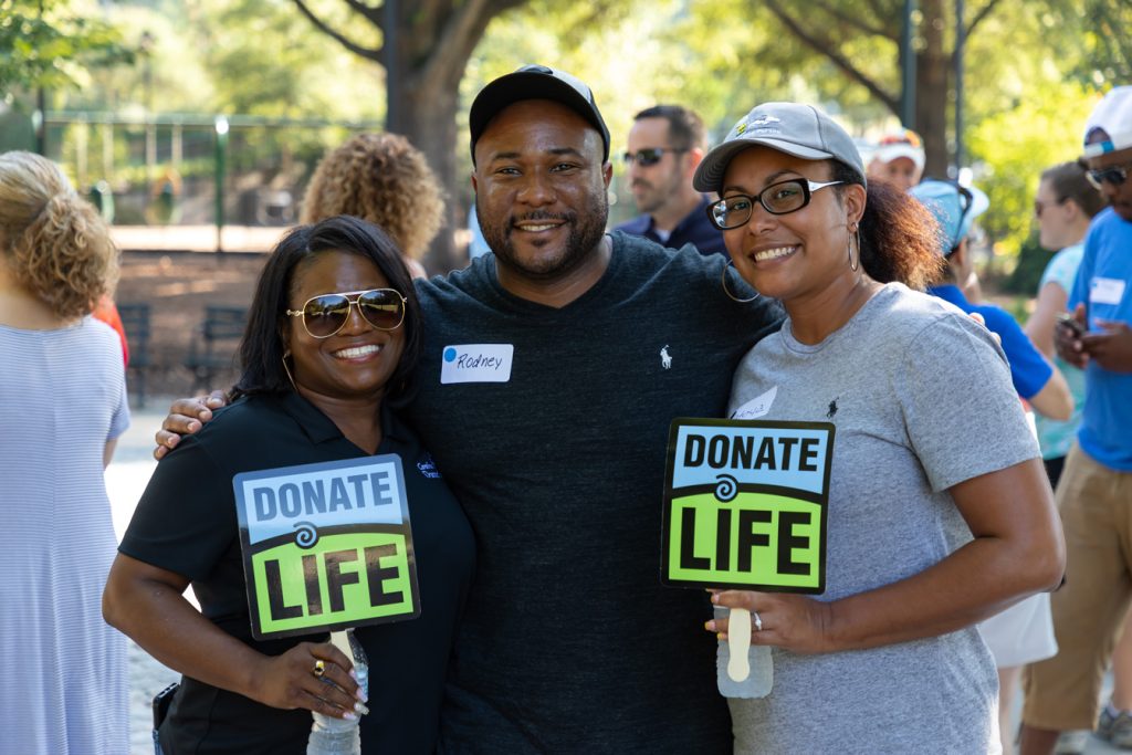 Three HonorBridge staff members holding Donate Life Signs at an event