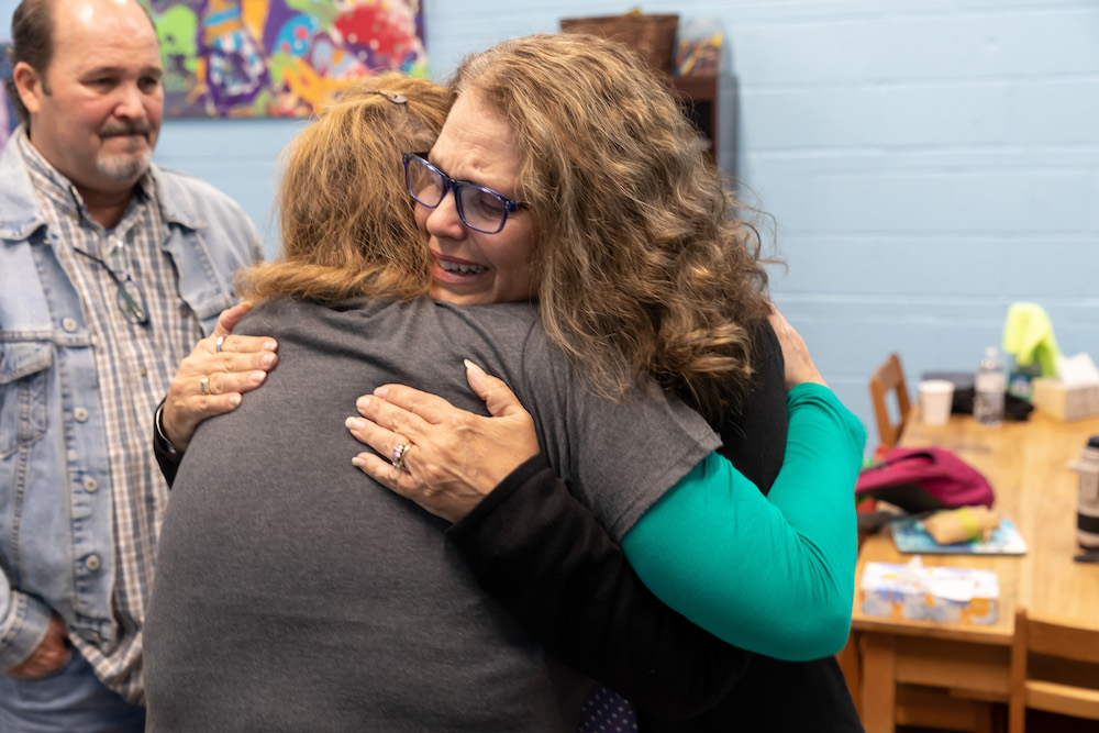 Two woman hug