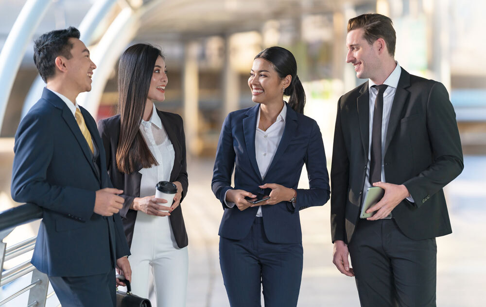 Four business men and woman talk in a hallway