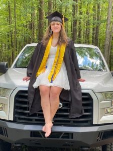 girl sitting on a truck in cap and gown