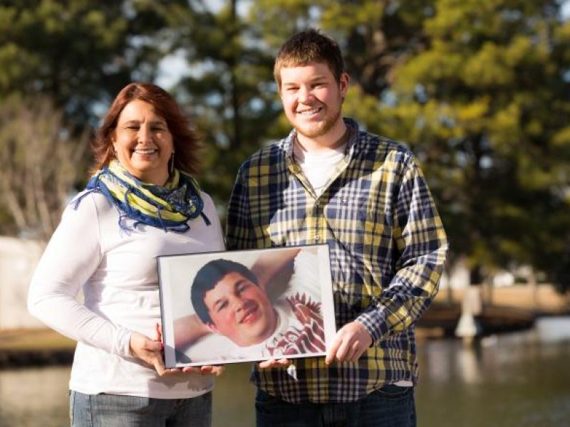 Organ donor mom, Angie, hold's photo of son by lake