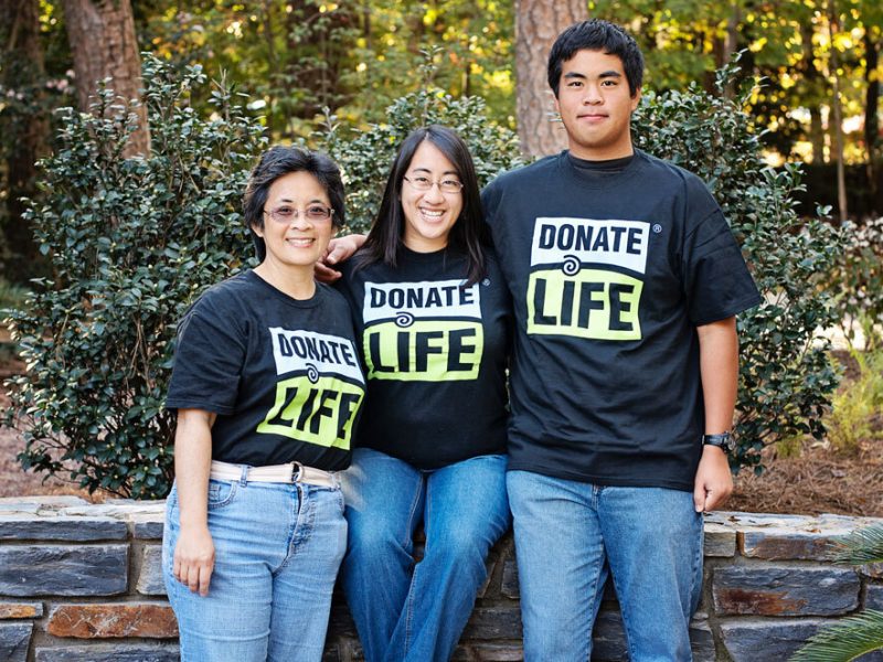Three donate life advocates wearing donate life t-shirts pose together