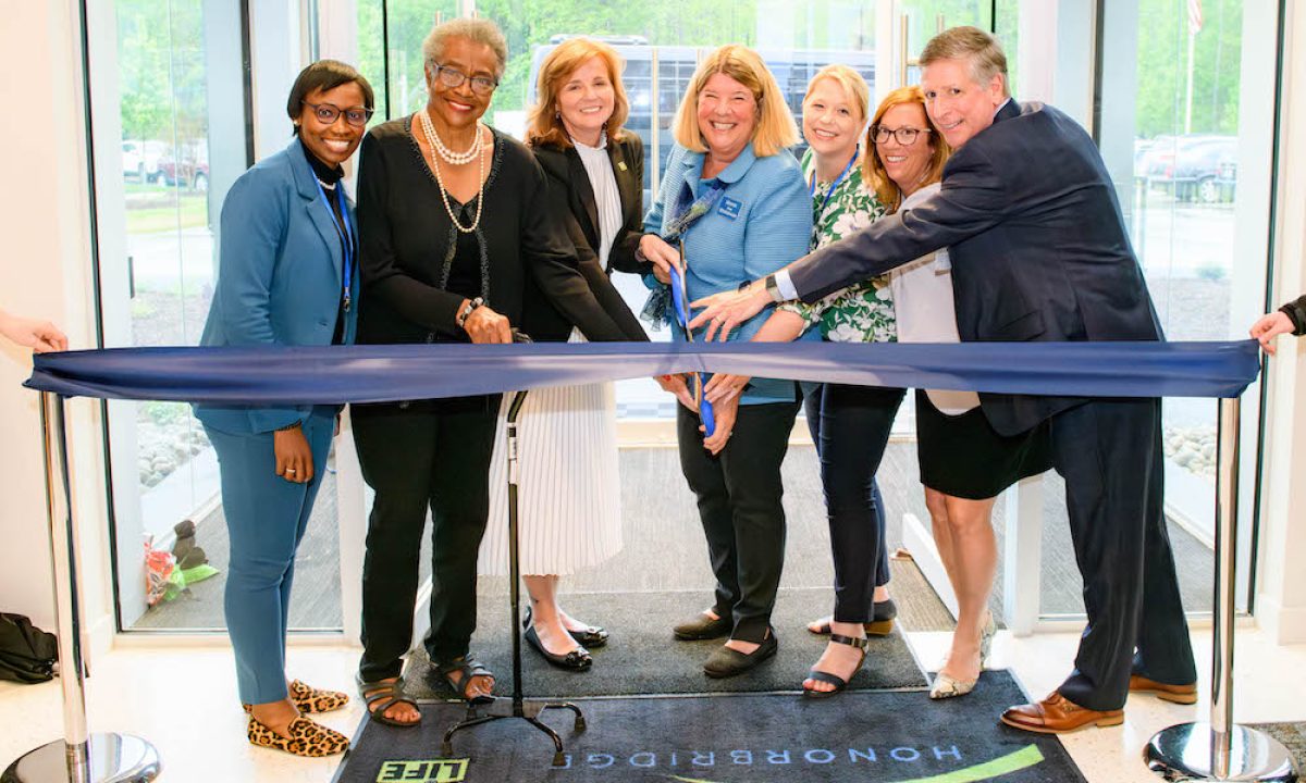 Danielle Bumarch and colleagues cutting the ribbon at HonorBridge office