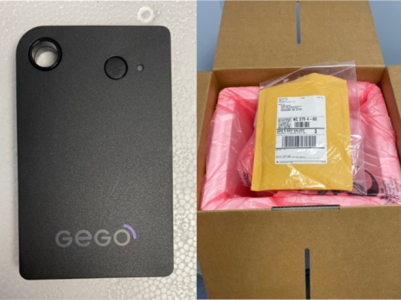 GEGO-Tracker. Black electronic deice next to a box