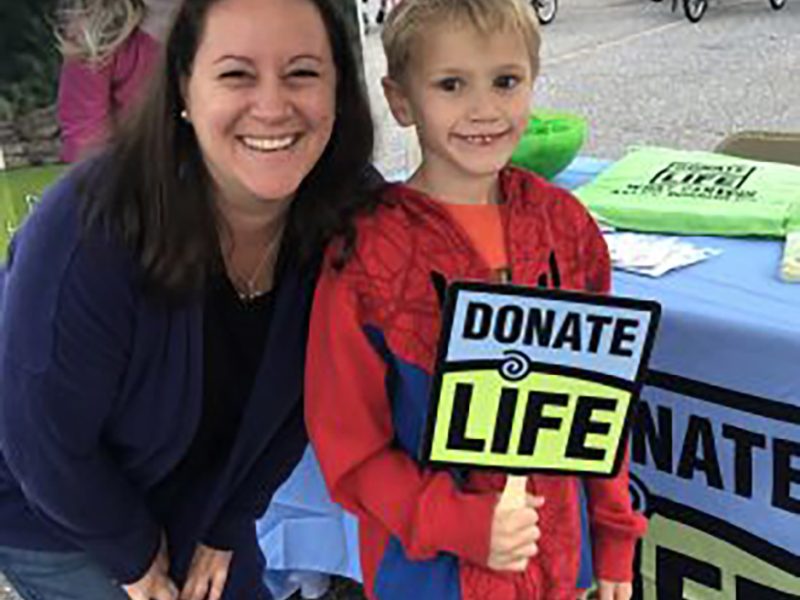 Woman and Child next to donate life booth