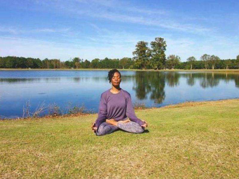 Organ recipient Phelicia relaxes on lawn by lake
