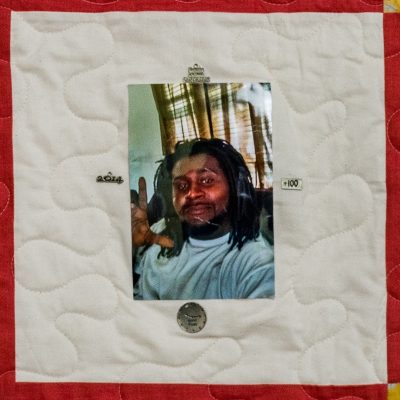 Quilt square for Roderick Robinson with a photo of Roderick waiving and four pins