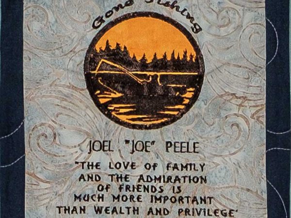 Quilt square for Joel Peele with illustration of a lake and a fisherman. Text reading: The love of Family and the admiration of friends is much more important than wealth and privilege. Charles Kuralt.