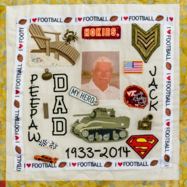 Quilt square for John Ryland with a photo of John and a collage of patches representing the military, the USA, racing, superman, the beach, and photography.