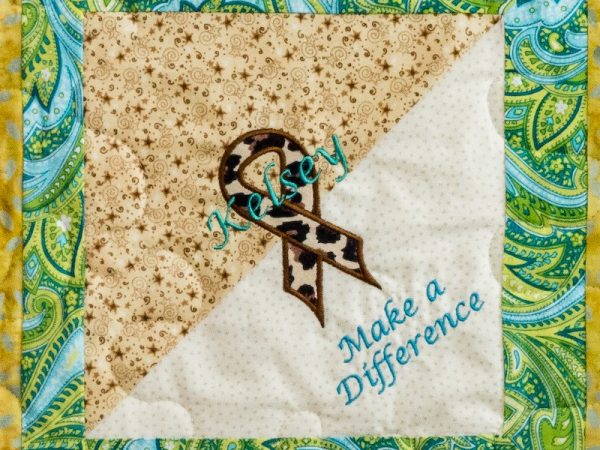 Quilt square for Kelsey Cooper with floral patterns and an awareness ribbon with text reading: make a difference.