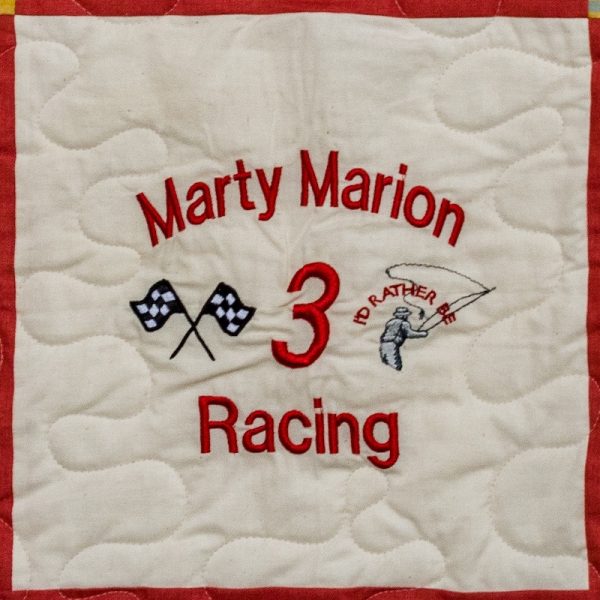 Quilt square for Marty Marion with racing flags, the number 3, and a fisherman. Text reading: Racing. I’d rather be fishing.