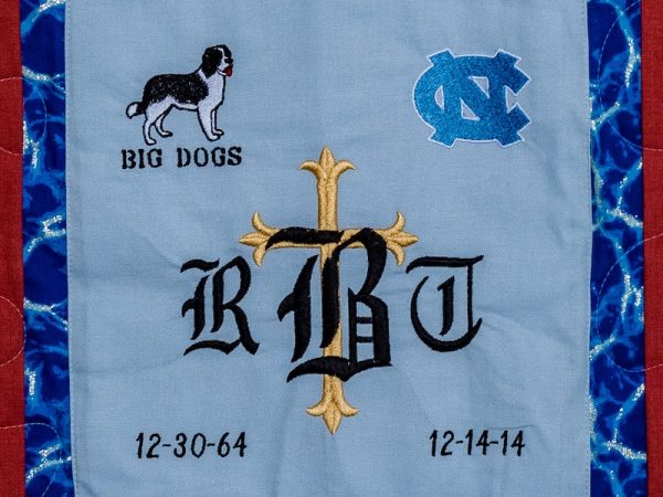 Quilt square for Roderick Bridges with patches for Big Dogs, UNC, and a cross.