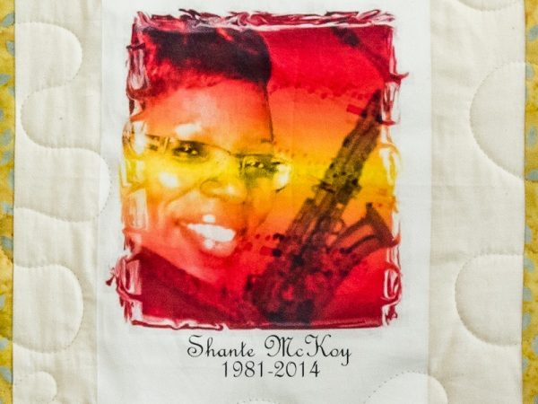 Quilt square for Shante McKoy with a styled photo of Shante and a saxophone.