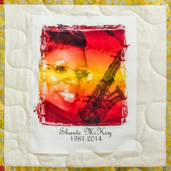 Quilt square for Shante McKoy with a styled photo of Shante and a saxophone.