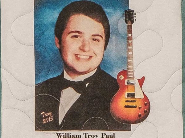 Quilt square for William Troy Paul with portrait photo of William and a guitar.