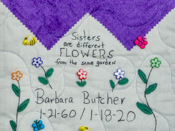 Quilt square for Barbara Butcher with text reading: Sisters are different flowers from the same garden