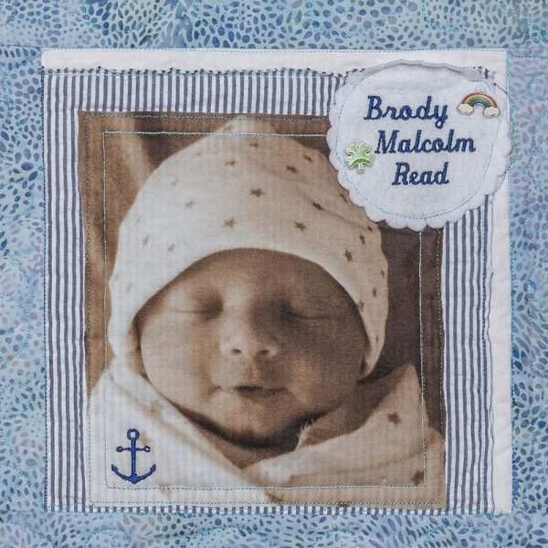 Quilt square for Brody Malcom Read with a picture of Brody, a rainbow, a clover, and an anchor.