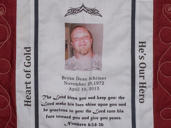 Quilt square for Bryan Schriner with a photo of Bryan and text reading: The lord bless you and keep you; the lord make his face shine upon you and be gracious to you; the lord turn his face toward you and give you peace.