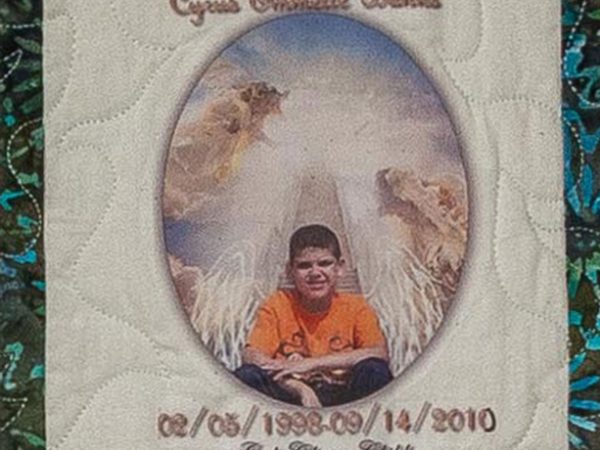 Quilt square for Cyrus Banks with photo of Cyrus sitting front of a glowing light.
