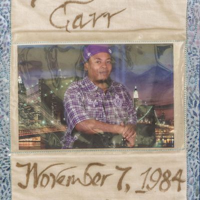 Quilt square for Demario Carr with portrait of Demario and backdrop of a city.