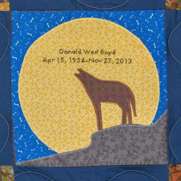 Quilt square for Donald Boyd with scene of a wolf howling at the moon.
