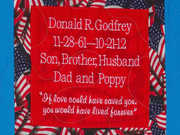 Quilt square for Donald R. Godfrey with American flags in the background and text read: If love could have saved you, you would have lived forever.