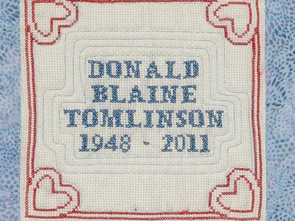 Quilt square for Donald Tomlinson with hearts in each corner.