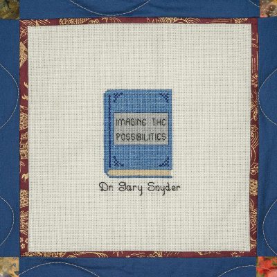 Quilt square for Dr. Gary Snyder with a book and title reading imagine the possibilities