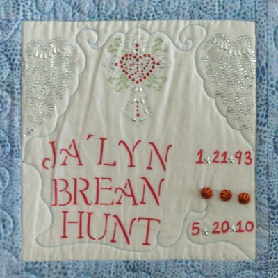 Quilt square for Jalyn Hunt with heart and cross, and three basketballs.