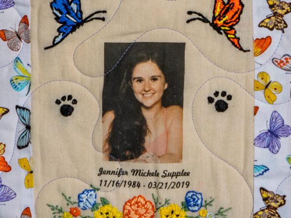 Quilt square for Jennifer Supplee with butterfly patterns and a portrait photo of Jennifer