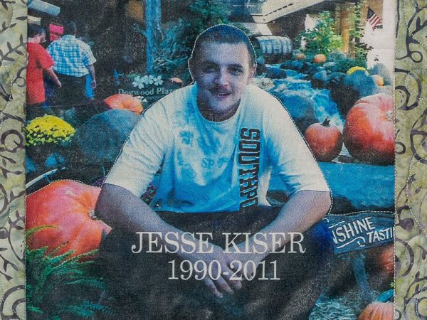 Quilt square for Jesse Kiser with a photo of Jesse sitting next to large pumpkins.