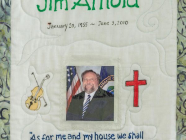 Quilt square for Jim Arnold with a photo of Jim and patches of a violin and a cross. Text reading: As for me and my house we shall serve the Lord. Joshua 24:15
