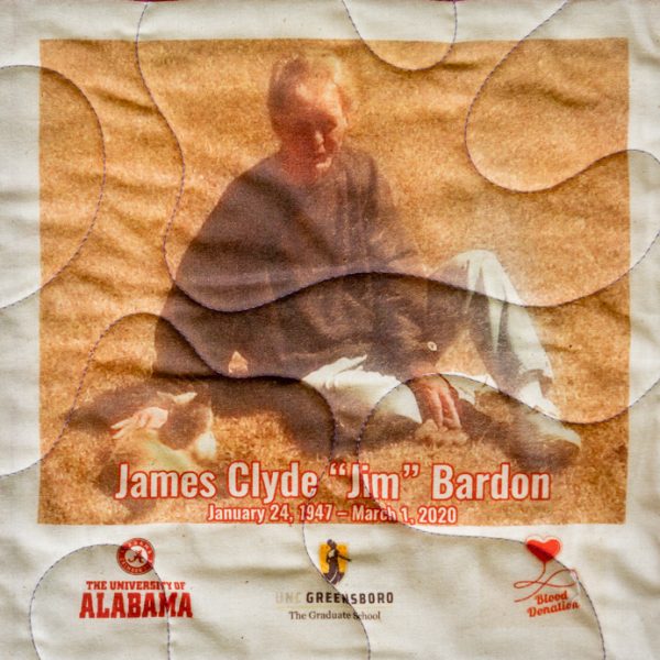 Quilt square for James Bardon with photo of James with a cat and logos for the University of Alabama, UNC Greensboro Graduate School, and Blood Donation