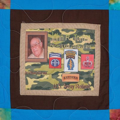 Quilt square for John Torress with Photo of John and patches airborne, special forces, ranger, ranger, and US Army retired.