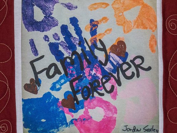 Quilt square for Jordan Sealey with colorful handprints and text reading: Family forever.