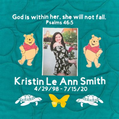 Quilt square for Kristin Smith with outdoor portrait of Kristen, Winnie the Poo, and text reading: God is within her, she will not fall. Psalms 46:5